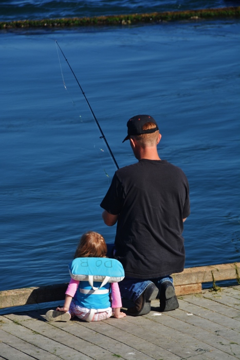 man and young daughter crabbing off dock